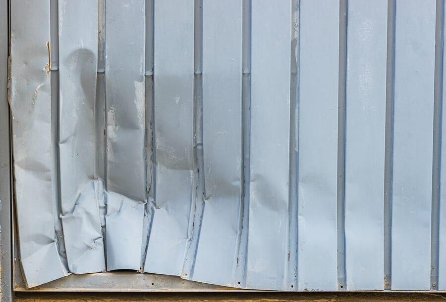 dented grey metal garage door